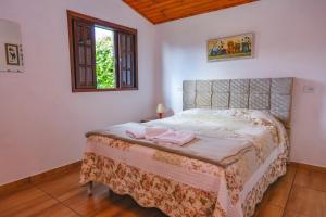 ein Schlafzimmer mit einem Bett mit zwei Handtüchern darauf in der Unterkunft Chalés Pedra do Baú in São Bento do Sapucaí