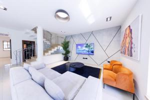 sala de estar con sofá blanco y sillas de color naranja en Large house with a Great Deal !, en Hod HaSharon