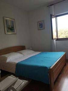 een slaapkamer met een groot bed en een blauwe deken bij Apartments with a swimming pool Stari Grad, Hvar - 4015 in Stari Grad