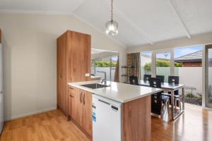 an empty kitchen and dining room with a counter top at Matipo Retreat - Christchurch Holiday Home in Christchurch