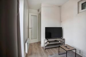 a living room with a flat screen tv on a stand at Cozy 1-Bed Apartment Close to Lcy & Excel in London