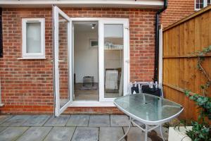 a patio with a glass table in front of a building at Cozy 1-Bed Apartment Close to Lcy & Excel in London