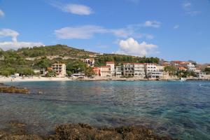 a view of a beach with buildings and the water at Apartments by the sea Milna, Hvar - 22619 in Hvar
