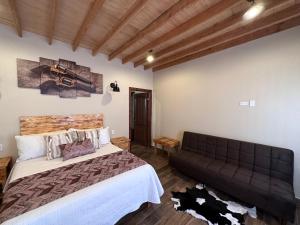 um quarto com uma cama grande e um sofá em Grape Valley Old West Cabins em Ensenada