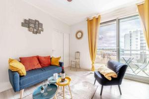 sala de estar con sofá azul y ventana grande en Appartement de 3 chambres avec terrasse amenagee et wifi a Gradignan, en Gradignan