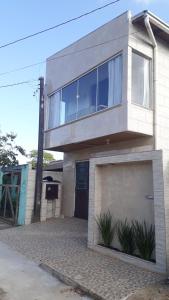 a large house with a balcony on top of it at Casa para Verão em Torres in Torres