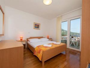 una camera con letto e vista su un balcone di Apartments by the sea Igrane, Makarska - 17292 a Igrane