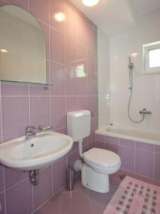 a bathroom with a sink and a toilet and a tub at Apartments by the sea Igrane, Makarska - 17292 in Igrane