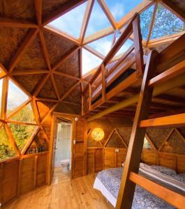 an attic bedroom with a large wooden ceiling at Huna Glamping in Guatavita