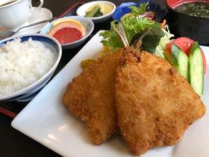 een witte plaat met twee stukken voedsel en rijst bij Hotel Alpha-One Mishima in Mishima