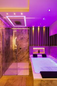 een badkamer met een bad en paarse verlichting bij AlbaDea Déco&Jacuzzi in Rome