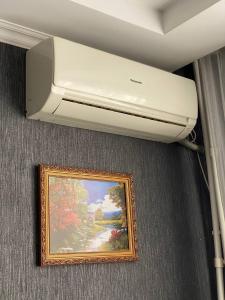 een airconditioner aan een plafond met een foto bij Уютный апартамент in Aqtöbe