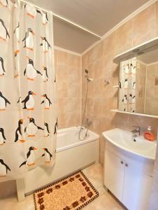 a bathroom with a shower curtain with penguins on it at Уютный апартамент in Aktobe