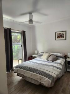 a bedroom with a bed and a ceiling fan at A quiet unit overlooking a reserve in Petrie