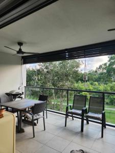 a room with a table and chairs and a large window at A quiet unit overlooking a reserve in Petrie