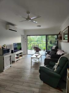 a living room with a couch and a tv at A quiet unit overlooking a reserve in Petrie