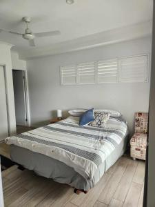 a large bed in a bedroom with white walls at A quiet unit overlooking a reserve in Petrie