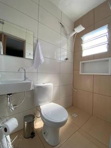 La salle de bains est pourvue de toilettes blanches et d'un lavabo. dans l'établissement Sobrado bem próximo ao Aeroporto, à Guarulhos