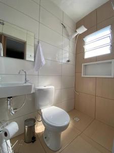 a bathroom with a white toilet and a sink at Casa bem próxima ao Aeroporto in Guarulhos +14 photos