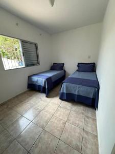 - une chambre avec 2 lits et une fenêtre dans l'établissement Sobrado bem próximo ao Aeroporto, à Guarulhos