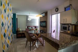 cocina y sala de estar con mesa y sillas en Casa vacacional disfruta junto al mar, en Manta