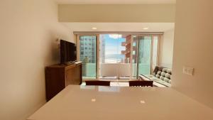 sala de estar con TV y ventana grande en Ocean View Retreat with Pool and Jacuzzi, en Tijuana