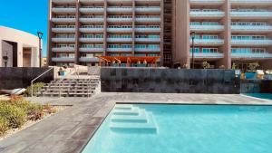 a swimming pool in front of a building at Ocean View Retreat with Pool and Jacuzzi in Tijuana