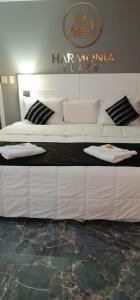 Cette chambre comprend un grand lit blanc et un canapé blanc. dans l'établissement Golden Flat's - Slaviero Guarulhos, à Guarulhos