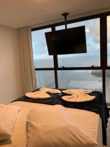 a bedroom with a bed with a large window at BARRA FLATS BY LOUI in Recife
