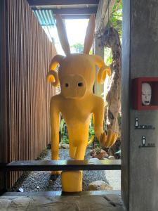 eine große gelbe Statue einer Kreatur mit Hörnern in der Unterkunft Mo rooms in Chiang Mai