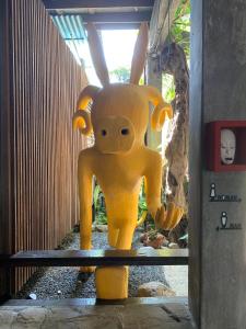 a large yellow statue of a creature with horns at Mo rooms in Chiang Mai