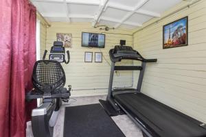 einen Fitnessraum mit einem Laufband und einem Stuhl in einem Zimmer in der Unterkunft Grange Motel in Auckland