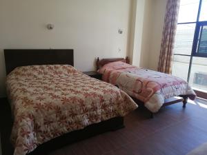 a bedroom with two beds and a window at Apartamentos MI FAMILIA in Sucre