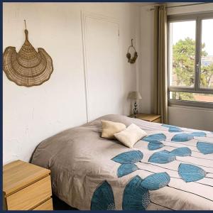 - une chambre avec un lit et une couette bleue et blanche dans l'établissement Confort Parisien - parking gratuit - Chaleureux, à Rueil-Malmaison
