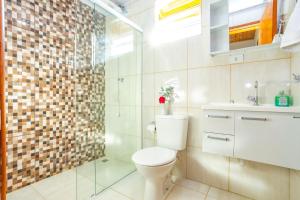 uma casa de banho com um WC e uma cabina de duche em vidro. em Chalés Pedra do Baú em São Bento do Sapucaí