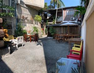 eine Terrasse mit Tischen, Stühlen und einem Sonnenschirm in der Unterkunft Mo rooms in Chiang Mai