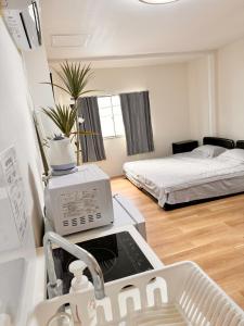 a kitchen with a sink and a bed in a room at 道頓堀House in Osaka