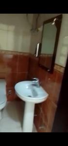 a bathroom with a white sink and a toilet at عمارة سكنية مخدومة قريبه من الحرم in Al Khansāk