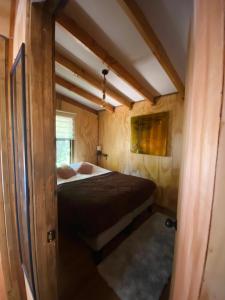 a bedroom with a bed in a small room at Cabañas Los Glaciares in Coñaripe +18 photos