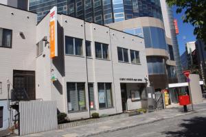 a white building on the corner of a city street at Sapporo Oriental Hotel in Sapporo