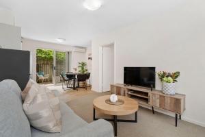 un salon avec un canapé bleu et une télévision dans l'établissement 2 Cute Cunningham Close To Subiaco - Sleeps 2, à Perth