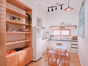 uma cozinha com uma mesa e um frigorífico branco em Denmaru em Sokcho