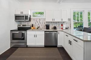 a kitchen with white cabinets and stainless steel appliances at Humble Bungalow 3 Miles DT in Atlanta