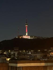 a city with a tower lit up at night at rhombus house in Seoul