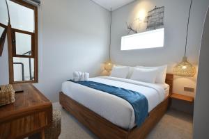 a bedroom with a large bed and a window at Sangkar Cottage & Eatery in Yogyakarta