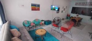 ein Wohnzimmer mit Stühlen, einem Sofa und einem TV in der Unterkunft Casa Holandesa con piscina privada in Mariquita