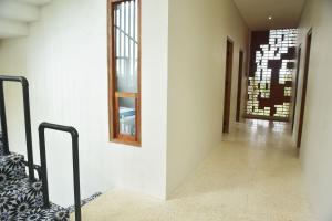 a hallway of a house with white walls and windows at Sangkar Cottage & Eatery in Yogyakarta +28 photos