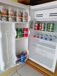 einen offenen Kühlschrank mit Dosen Soda in der Unterkunft Ana Terra Barretos Casa de Campo in Barretos