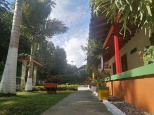 einen Bürgersteig neben einem Haus mit Palmen in der Unterkunft Casa de campo Jardín in Jardin