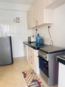 a kitchen with a black counter top and a refrigerator at Adjana’s Cozy apartment in Nairobi
